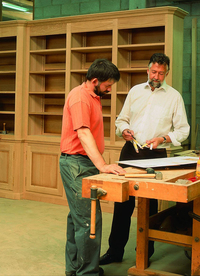 René Rigaux et son chef d'atelier discutant de plan pour réalisation biliothèque sur mesure en chêne massif René Rigaux et son chef d'atelier